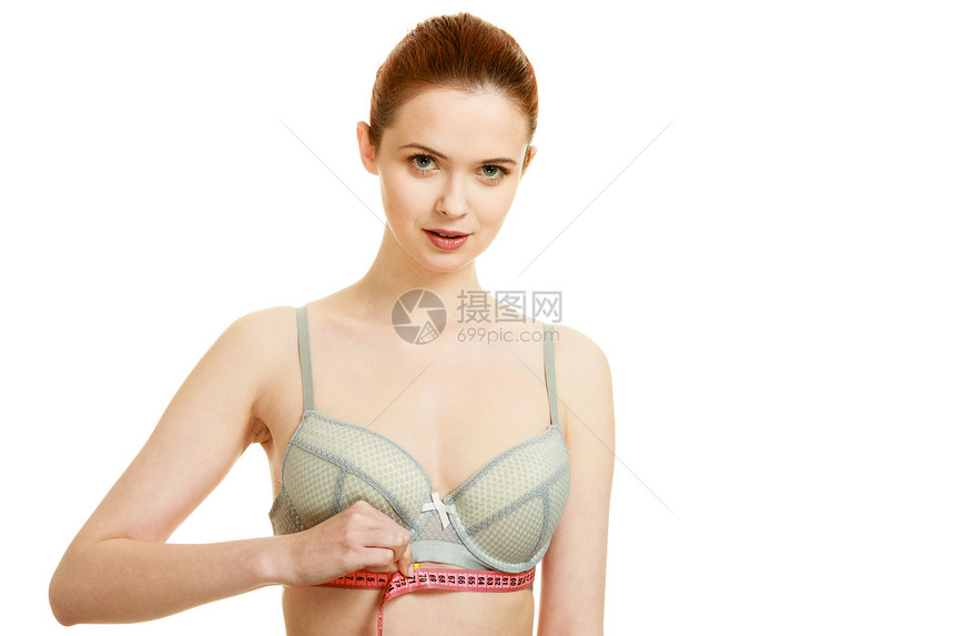 女人苗条的女孩穿着胸罩内衣,用红色的测量带测量她胸部下的胸部白色上隔离女人乳房下测量她图片