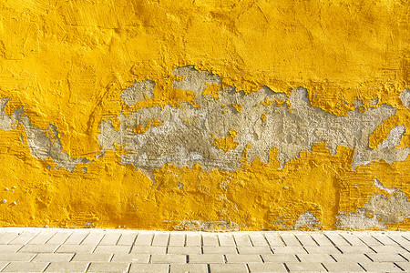 旧风化漆黄色剥落墙灰背景图片
