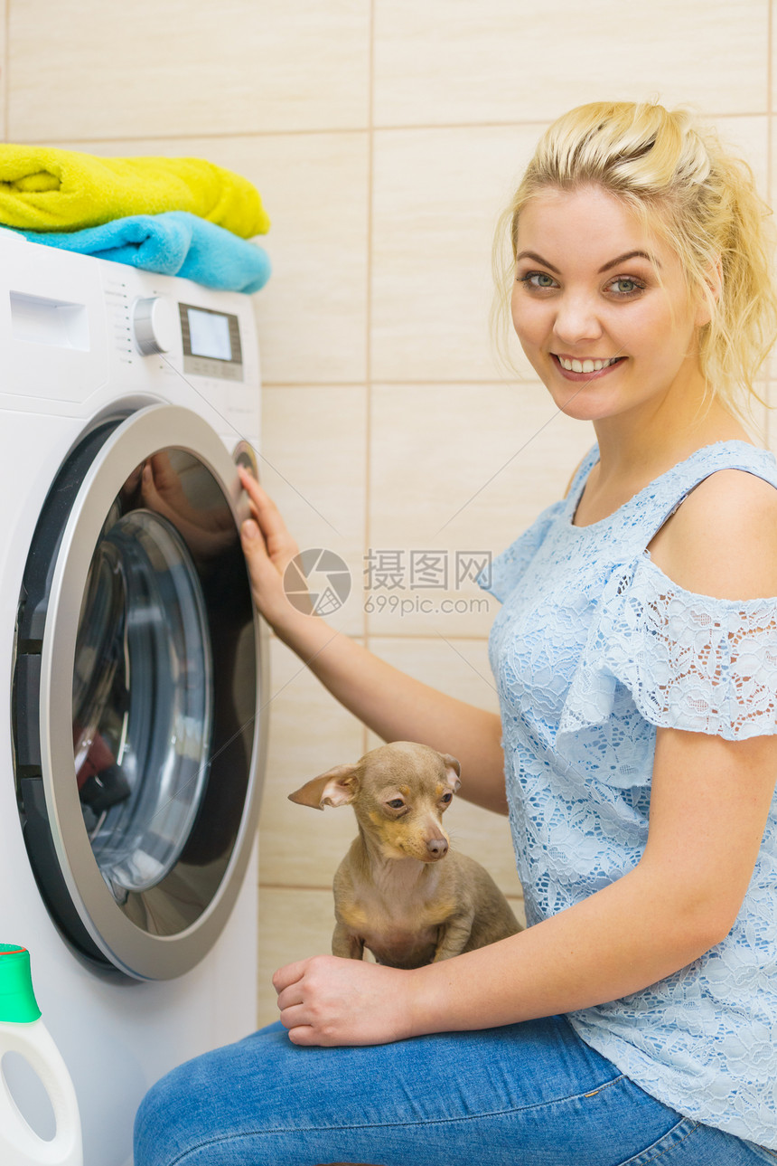 轻的金发女人洗衣机旋钮,选择程序家务妇女洗衣机图片