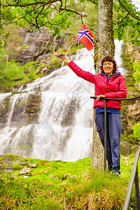 罗森达尔挪威的斯万达尔斯福森挪威的旅游妇女,挪威山区的强大瀑布旅游Ryfylke路线挪威瀑布svandalsfosse背景