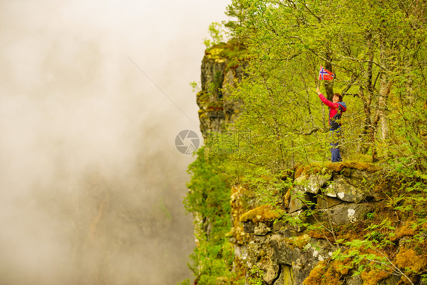 挪威的旅游妇女朦胧的雾山自然朦胧的山上悬挂挪威的游客图片