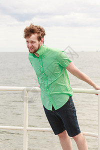 暑假放松的轻的时髦男人码头放松,享受户外海风图片