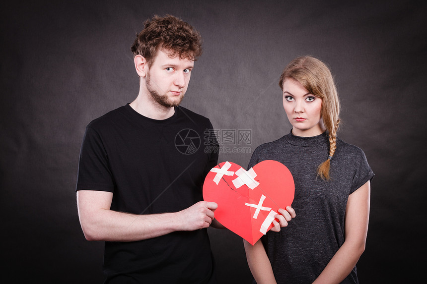 破碎的心困难的爱的悲伤幸的夫妇,女人男人着纸,红心用石膏绷带固定感情上的裂痕悲伤的夫妇抱着破碎的心图片