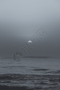 日落时海滩上拍摄雾云后的黑白照片日落时的黑白太阳图片