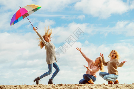 三个充满喜悦的女人度过了美好的时光个女人着五颜六色的伞女人着伞朋友玩图片