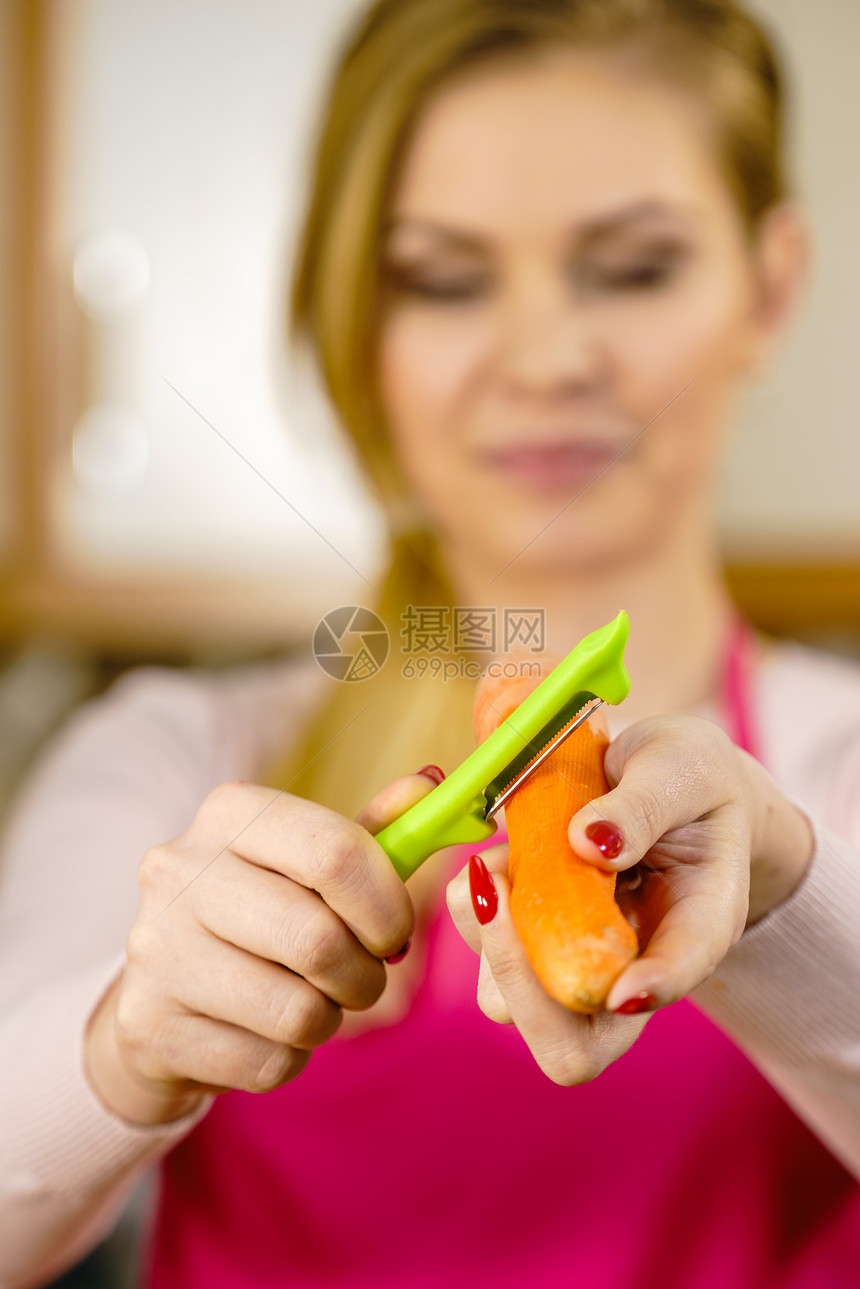 女人用食物剥皮机剥蔬菜烹饪女上菜前先准备胡萝卜图片