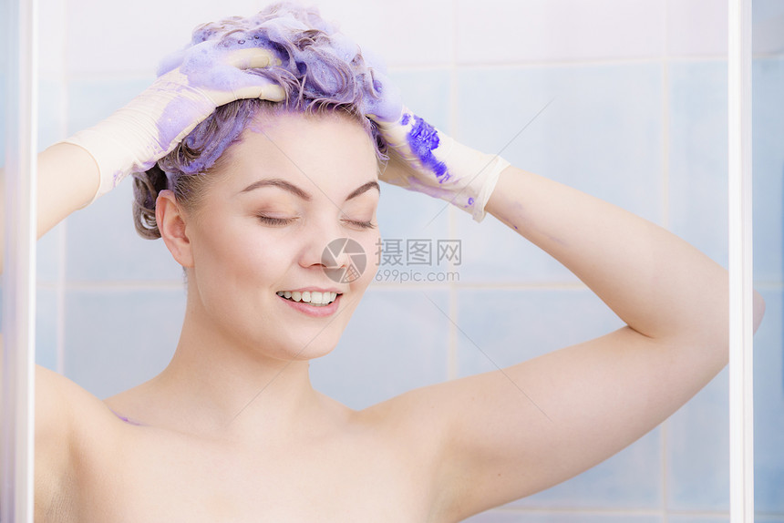 女人头发上涂上着色洗发水紫色洗涤产品的女家里涂金色女人头发上涂墨粉洗发水图片