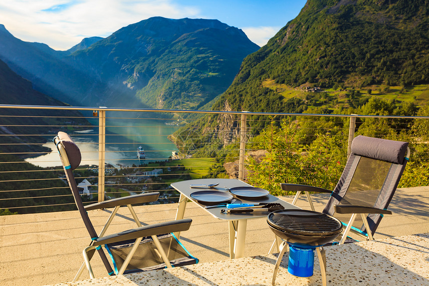 晚餐桌子与烧烤室外挪威山区,可以看吉兰格峡湾旅游,大自然上露营晚餐餐桌上挪威大自然的烤架图片