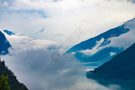 Fjaerland峡湾景观与云层覆盖水,挪威斯堪的纳维亚挪威峡湾景观背景