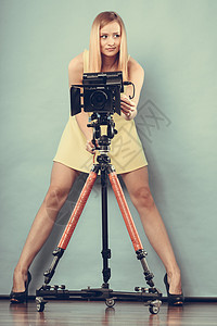 摄影师女孩拍摄图像魅力的时尚金发女人蓝色上用相机拍照背景图片