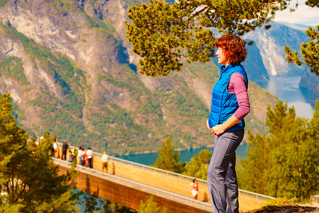 斯特加斯坦游客妇女越过Stestein瞭望台,看着挪威峡湾山脉的景色徒步旅行,旅途放松旅游景区路线极光游客享受山脉峡湾景背景