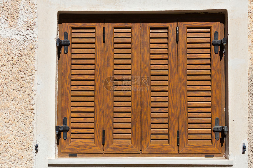 希腊石墙上的传统棕色百叶窗窗口传统的棕色百叶窗窗口,希腊图片