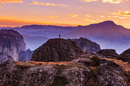 日落时游客山上,人悬崖上的岩石塞萨利希腊旅游度假旅游旅游山区流星希腊背景图片