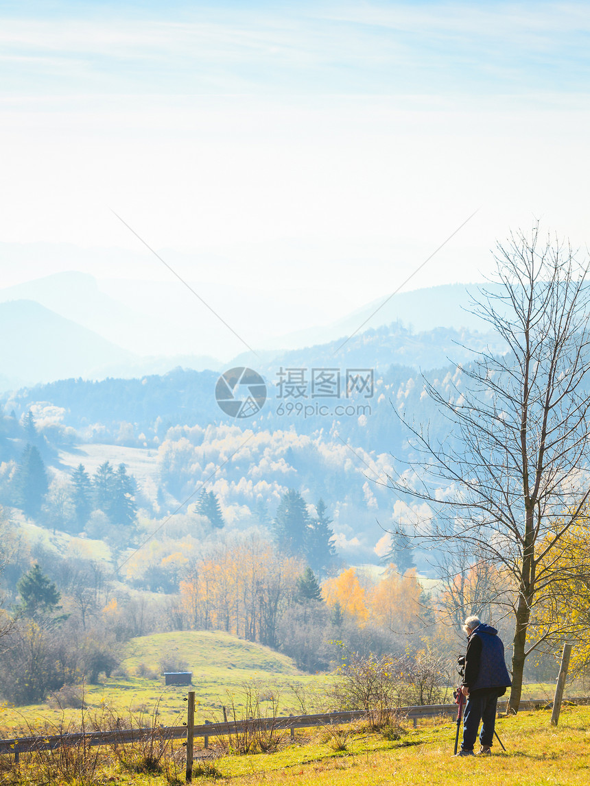 男摄影师拍摄秋季秋季雾山景观斯洛伐克Tatras秋色的树木山上季节自然风光秋季雾山景观斯洛伐克图片