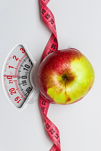 节食健康饮食减肥理念特写苹果与测量磁带白色重量秤图片