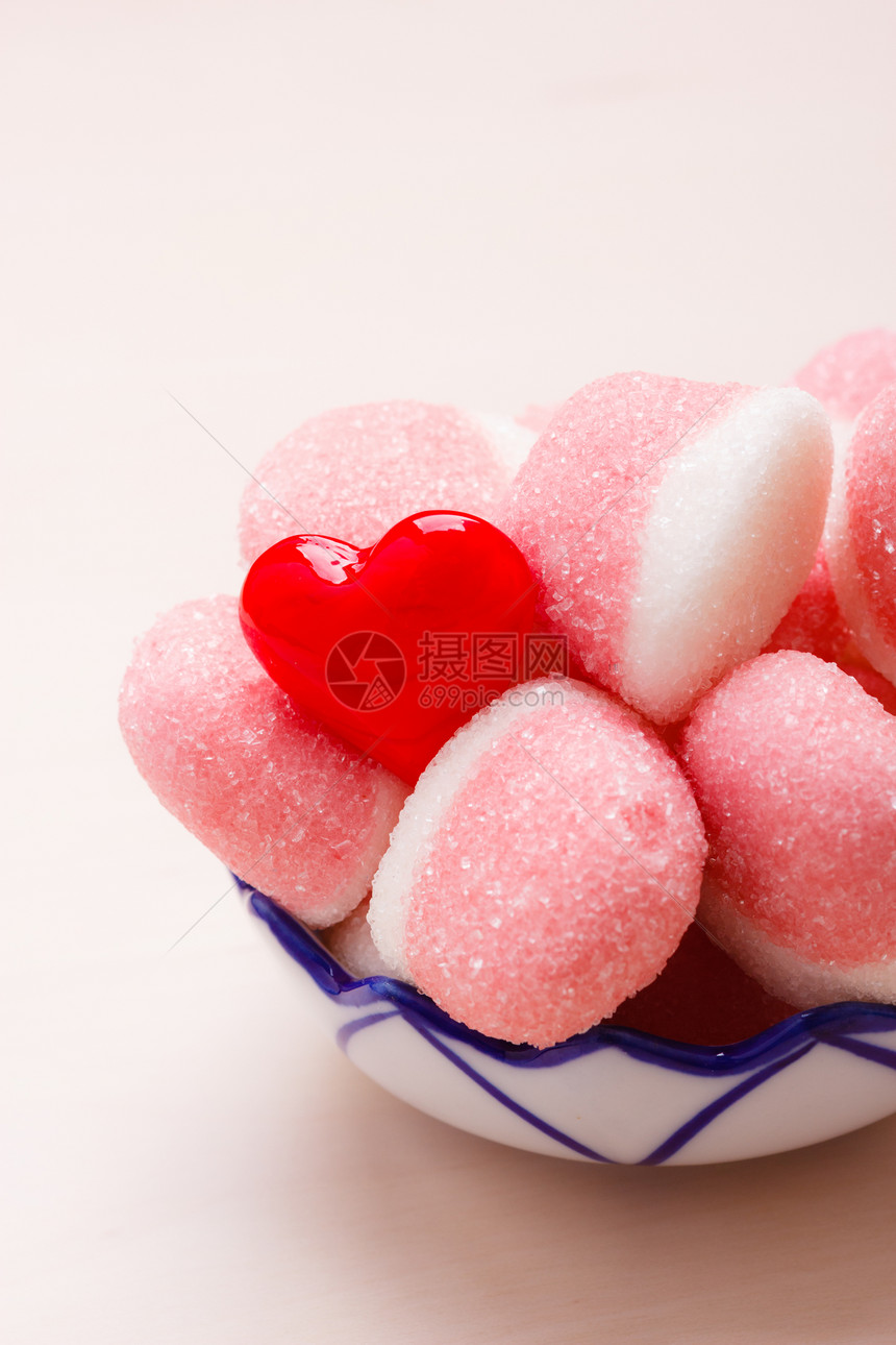 甜食糖粉红色果冻棉花糖,碗里糖,放木桌上,装饰着红色的心爱符号图片