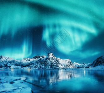 黄石市磁湖北极光雪山上,冰冻的海岸挪威洛福滕岛的水中的反射北极光冬季景观与极地灯,冰水中天空星星极光雪山上方的北背景