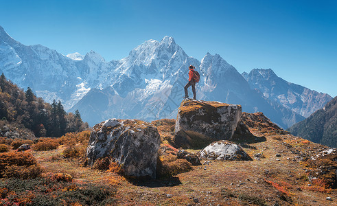 比利茨基高峰站着的女人,背着背包石头美丽的山日落风景与运动女孩,高岩石,雪峰,蓝天秋天尼泊尔旅行生活方式喜马拉雅背景