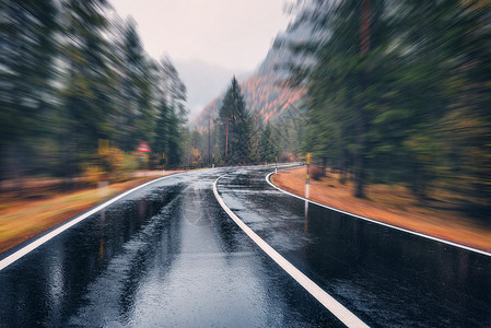 秋林雨中运动模糊的效果，沥青山路阴雨天,背景模糊道路中公路快速驾驶背景图片