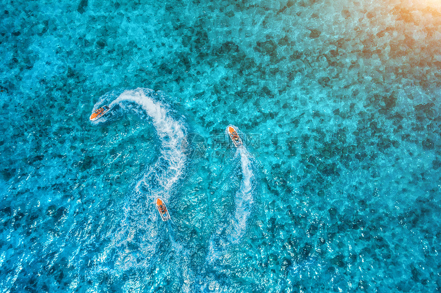 夏季日落时,清澈的蓝色水中漂浮的水上滑板车的鸟瞰图非洲桑给巴尔度假喷气滑雪运动的顶部视图热带海景与移动摩托艇图片