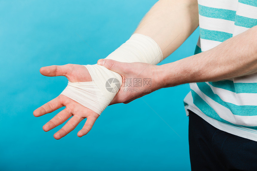 疼痛伤害的轻人握着绷带的手身体受伤的部分医学医疗保健用痛苦绷带的手的人图片