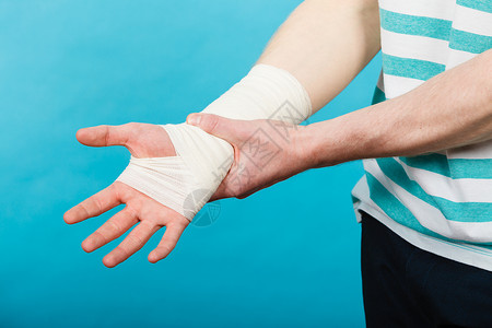 保护坏境疼痛伤害的轻人握着绷带的手身体受伤的部分医学医疗保健用痛苦绷带的手的人背景