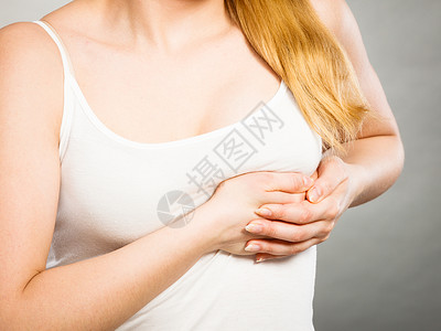保护乳房健康问题的轻的生病的女人感种刺痛,抚摸着灰色的胸部患剧烈胸痛的女人背景