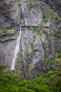 岩石石头悬崖,瀑布环绕着绿色的苔藓背景与自然细节岩石石头悬崖与瀑布图片