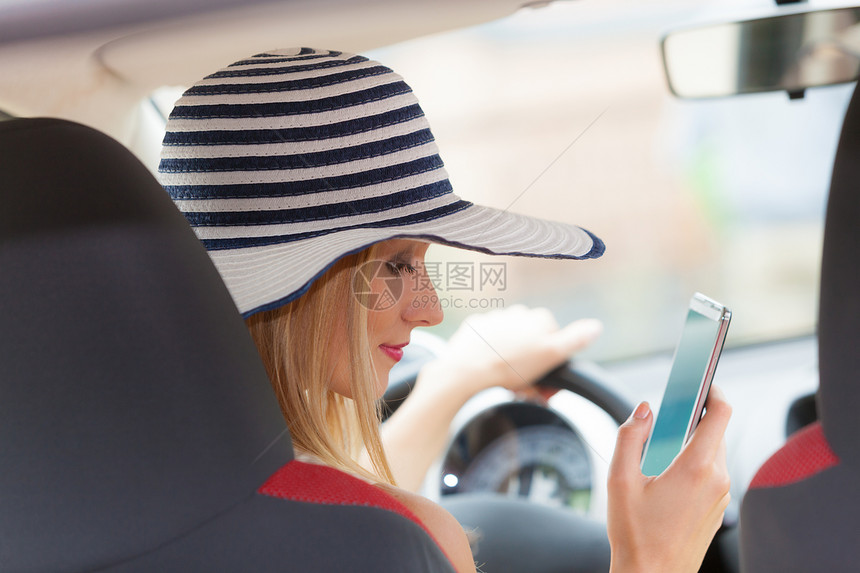 分心的司机轻迷人的女人开车时用手机短信阅读信息开车时用电话的女人图片