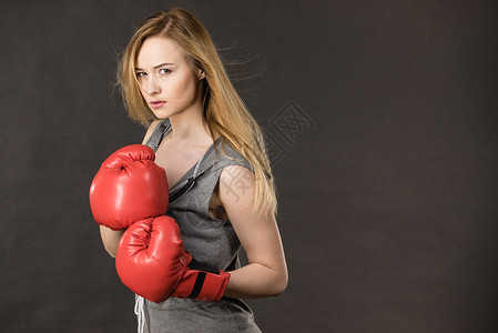 跆拳道女孩轻的感女人,金发迷人的女孩戴着红色拳击手套摆姿势运动健身力量戴着红色拳击手套的漂亮女人背景