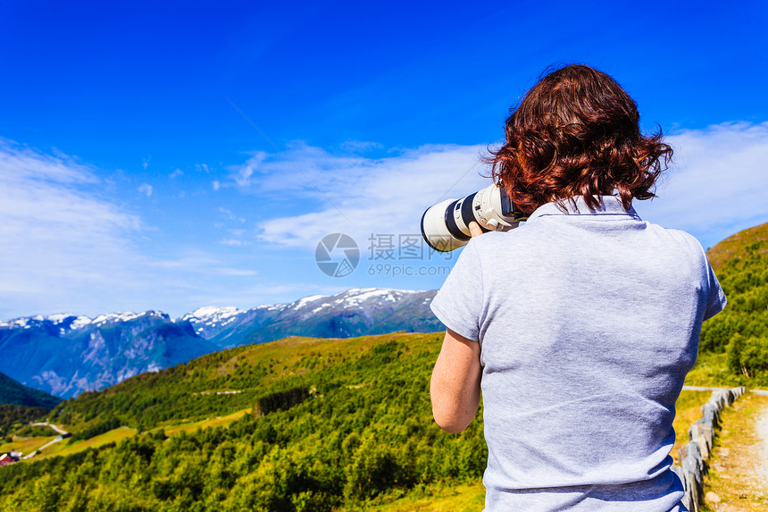 旅游度假旅游女游客用相机拍照,欣赏风景优美的夏季景观挪威斯堪的纳维亚游客挪威自然中拍照图片