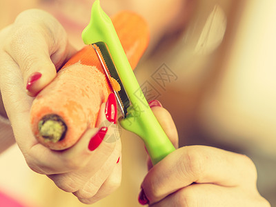 女人用食物剥皮机剥蔬菜烹饪女上菜前先准备胡萝卜高清图片