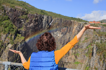 哈丹格维达旅行,假期游客女人看着沃林斯福森瀑布还彩虹马博登峡谷挪威旅游哈丹戈维达路线,伊德福德观光旅游挪威沃林斯福背景