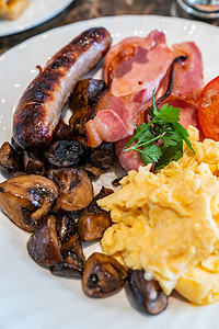 布朗蘑菇丰盛的英式早餐咖啡桌子上背景