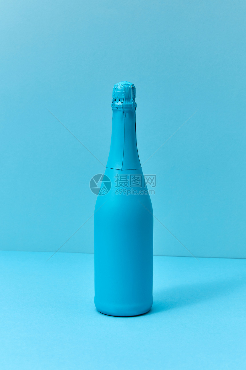 单调的蓝色构图画香槟模拟瓶与软阴影与最小的假日香槟模拟瓶子涂成蓝色的软阴影图片