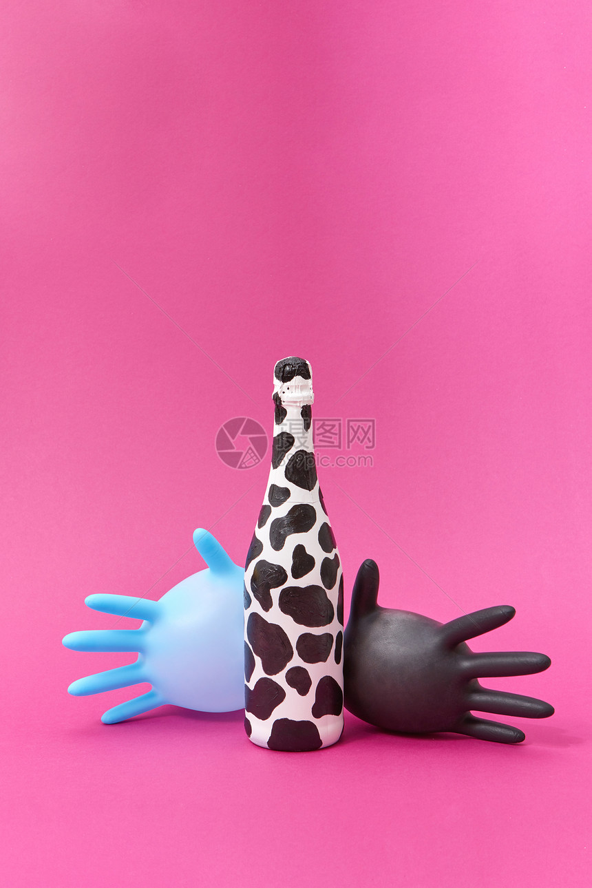 创造的构图与油漆酒瓶的黑点两个橡胶外科气球手套个热粉色背景,两个气球乳胶手套与斑点酒瓶油漆图片