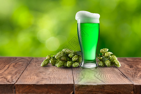 泡沫机天然机啤酒花的,自然模糊的背景下,木桌上放杯新鲜的冷绿啤酒,快乐的帕特里克日用杯新鲜的绿色啤酒背景
