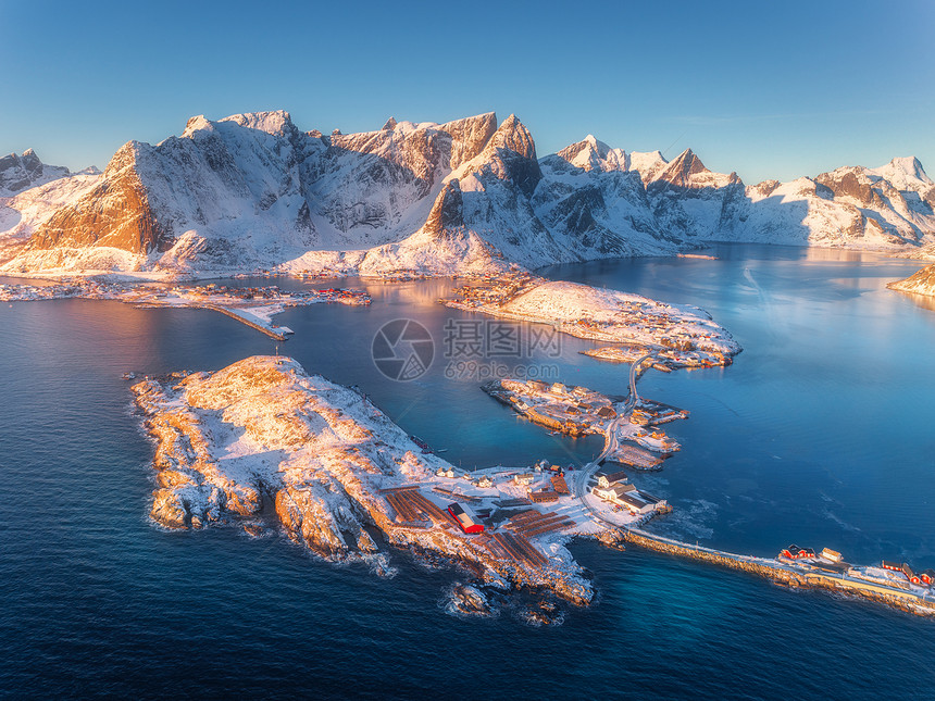挪威洛福滕岛的小岛桥上的海上雪山的鸟瞰图汉诺伊冬天日出的时候景观与碧水,岩石,建筑物,罗布道路的风景图片