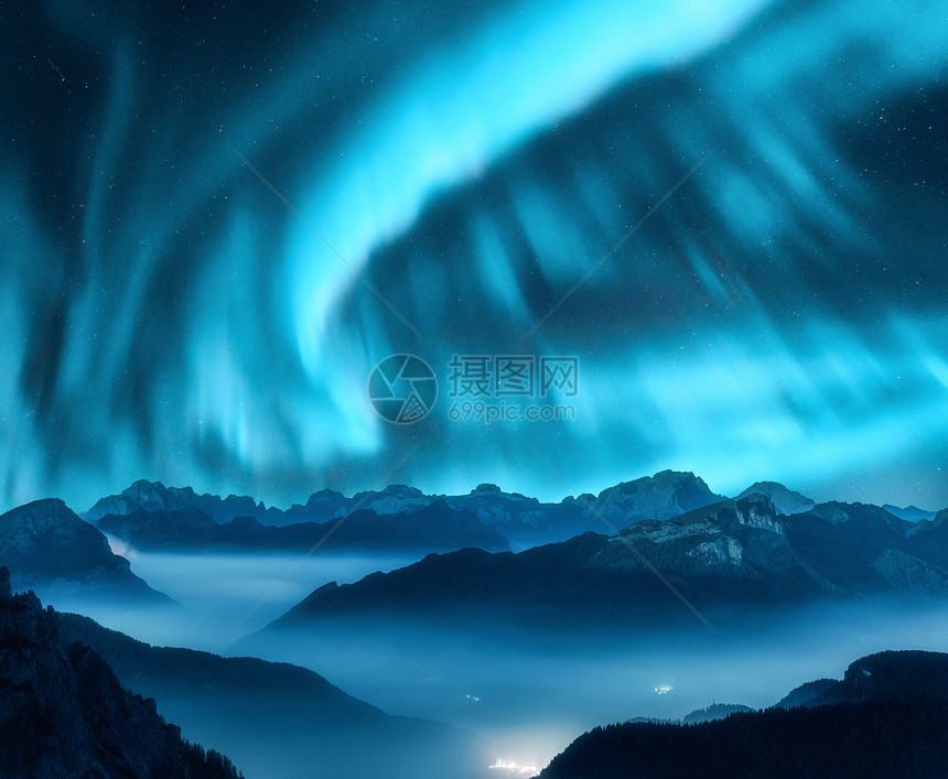 北极光夜间雾中笼罩山上北极光天空中北极光高岩石的星星美丽的风景与极光,城市灯低云,山峰图片