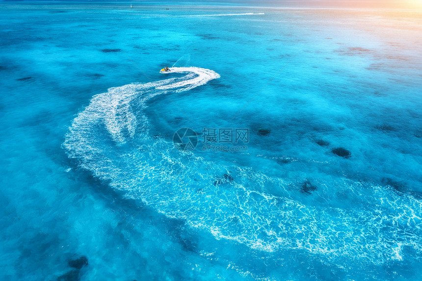 夏季日落时蓝色水中浮水滑板车的鸟瞰图印度洋,桑给巴尔,非洲度假喷气滑雪运动的顶部视图热带海景与移动摩托艇极端图片