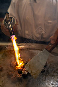 烤牛肉铁板烧食谱日本烤牛肉烹饪锅与刮刀煤气燃烧器火焰背景图片