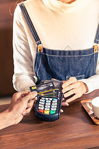 非接触式支付特写亚洲客户用他的信用卡与非接触式NFS技术支付咖啡师购买咖啡咖啡馆酒吧背景