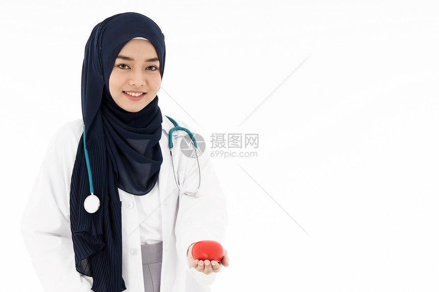 亚洲轻的成人,吸引力的穆斯林女医生,戴着头巾,站听诊器上,着白色背景的红色心脏医疗保险图片