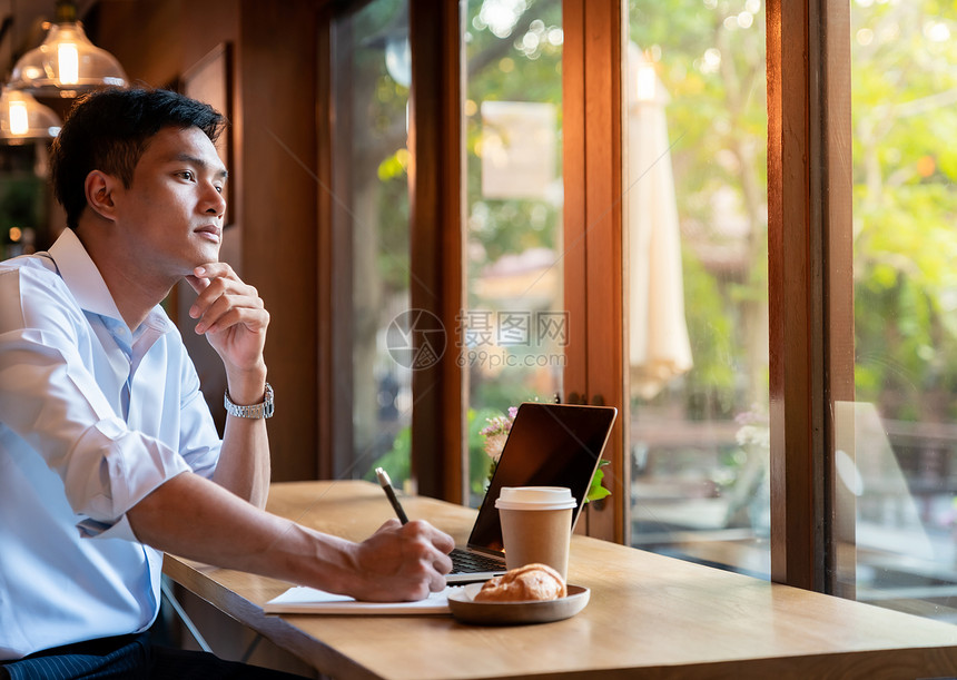 专注的亚洲大学生咖啡馆用笔记本电脑为考试考试准备图片