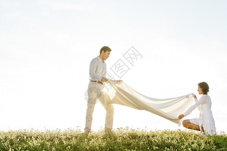在阳光明媚的白天在草地上撒野餐毯子高清图片