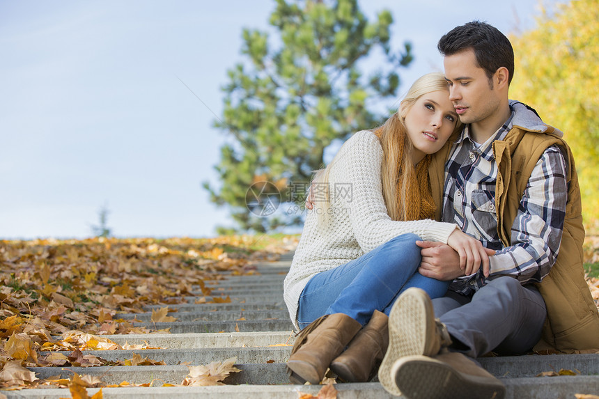 坐在公园台阶上的情侣图片