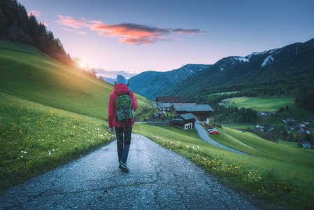 绿色小背包带着背包的年轻美女在秋天日落时站山路上背景
