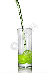 将绿汁倒入白色的隔绝玻璃杯中高清图片