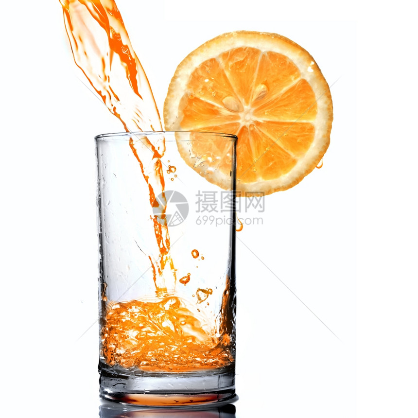 橙汁灌入玻璃杯中图片