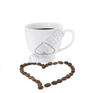 在白色背景里的咖啡杯和咖啡豆摆出的爱心背景图片